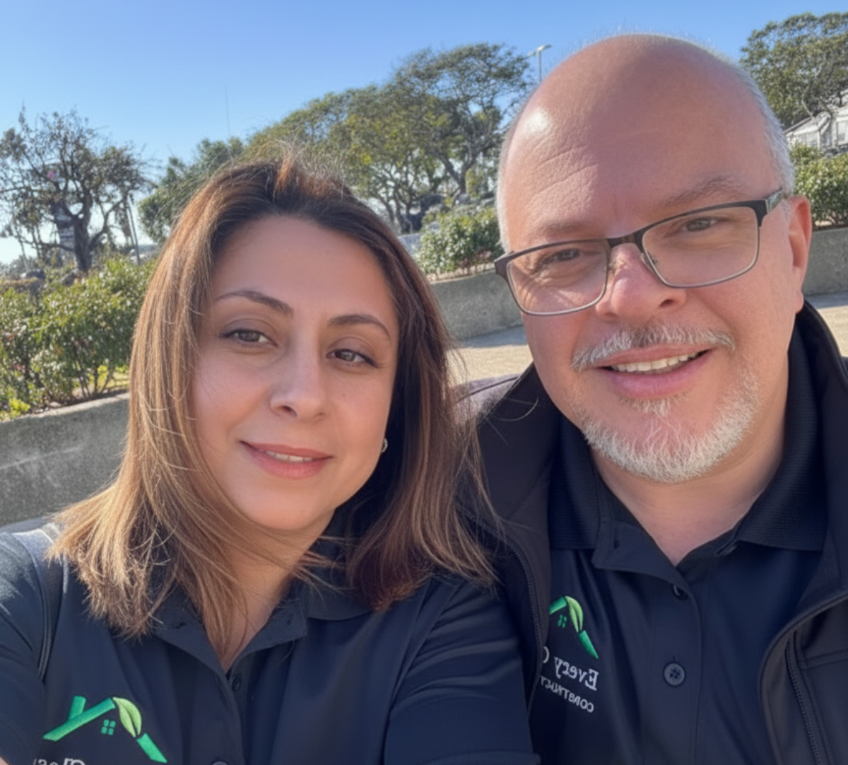 Mauro and his wife smiling outdoors in Every Class Construction shirts.